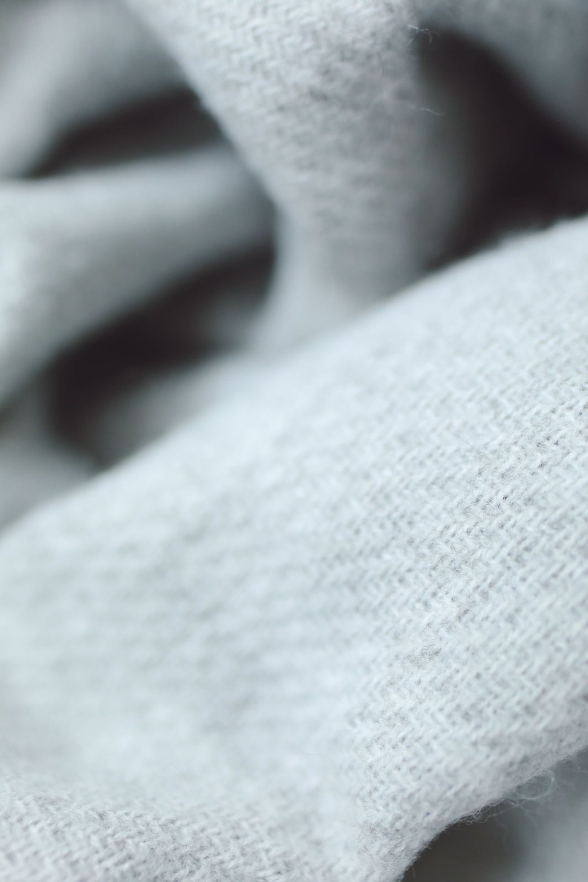 Close-up of folds in a soft pale gray woven blanket